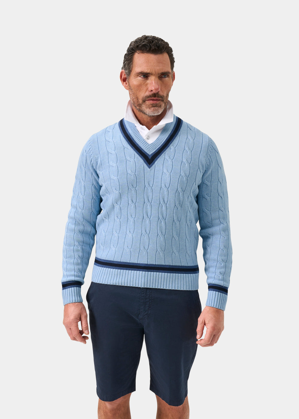 Steel blue cotton cable knit V-neck jumper with dark navy trim, worn over white shirt, front view