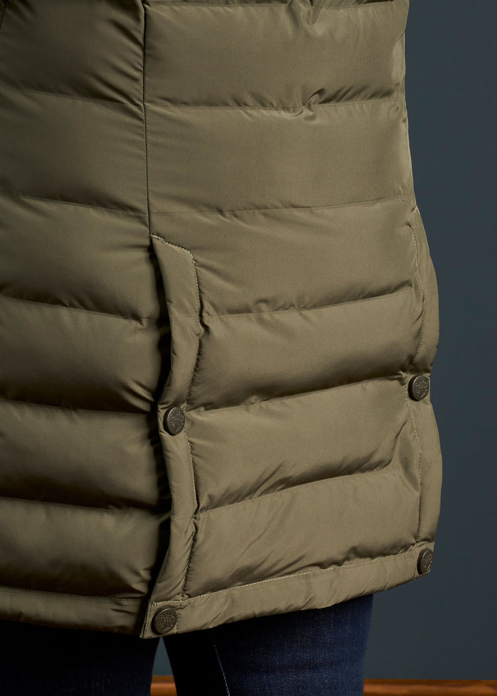 Close-up of Calsall Ladies Coat in Olive - Regular Fit, featuring snap buttons, styled with dark denim jeans.
