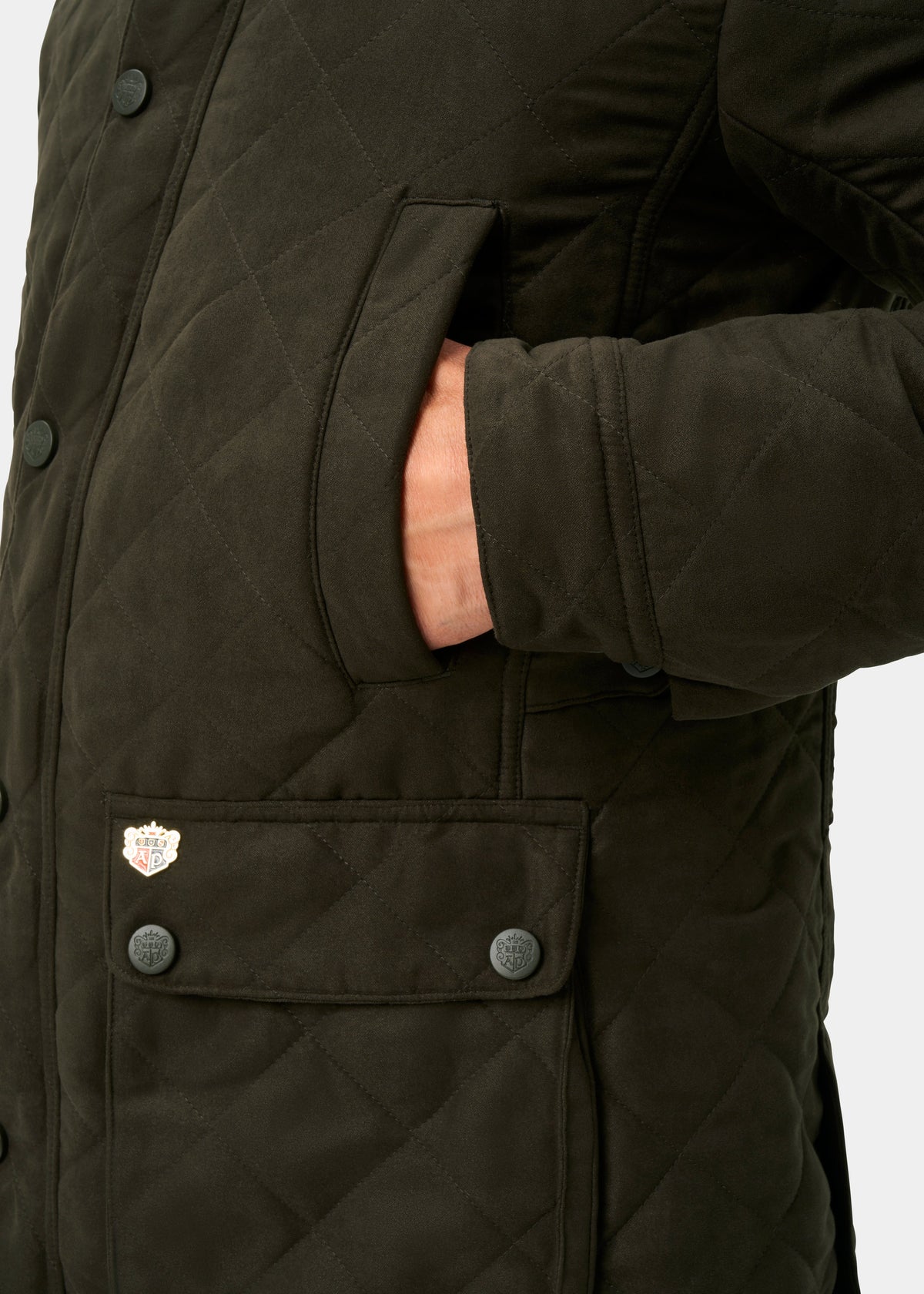 A hand in the pocket of the Felwell Men’s Olive Quilted Jacket, regular fit, with black buttons and crest patch.