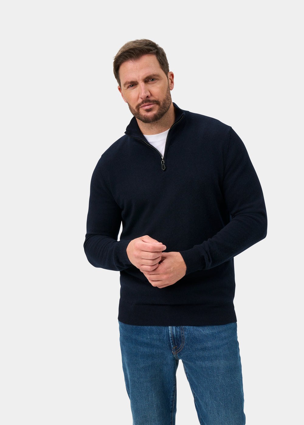 Man wears Hanbury Pure Cashmere Quarter Zip Jumper in Dark Navy, regular fit, with jeans against a gray background.