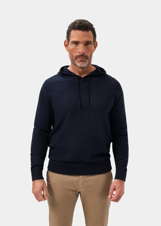 Man in Gaisby Cotton Merino Hoodie in Dark Navy stands facing forward against a plain white background.