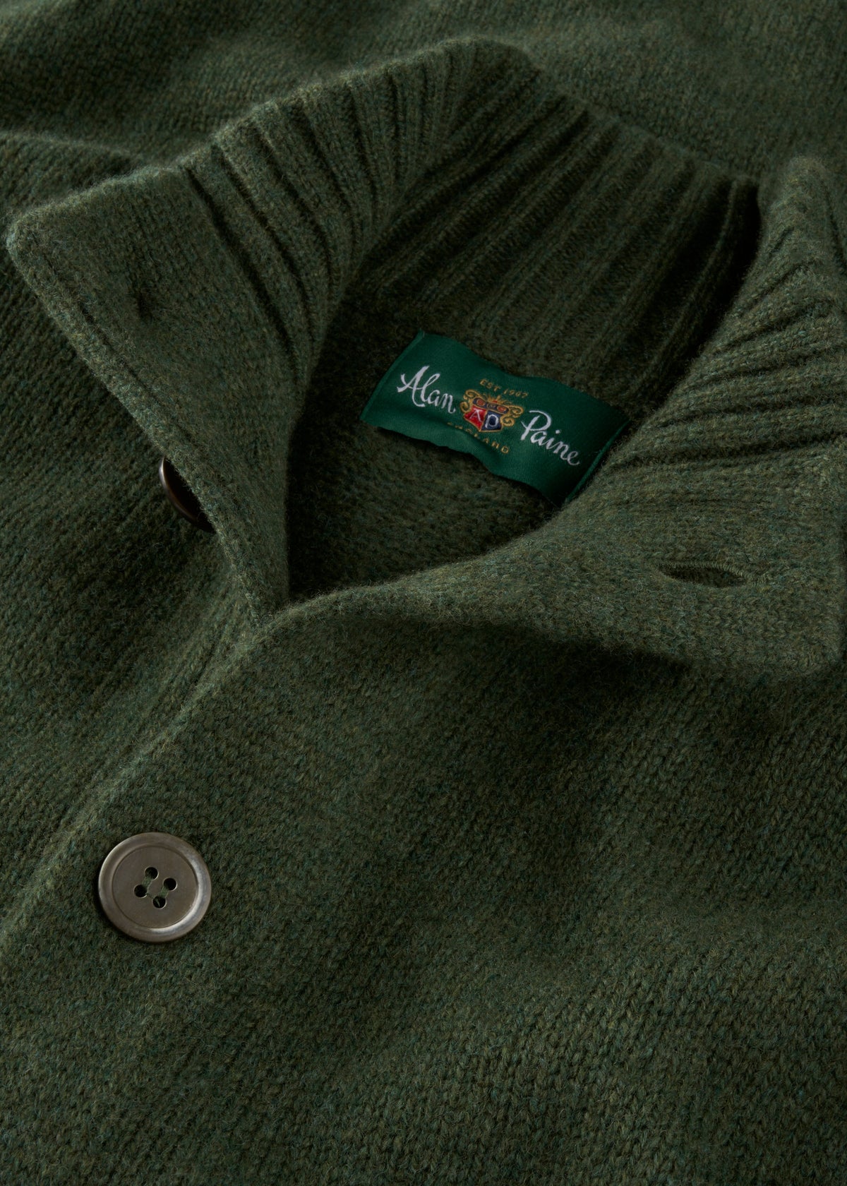 Close-up of the Landford Lambswool Buttoned Mock Neck Jumper in rosemary, featuring ribbed collar and two buttons.