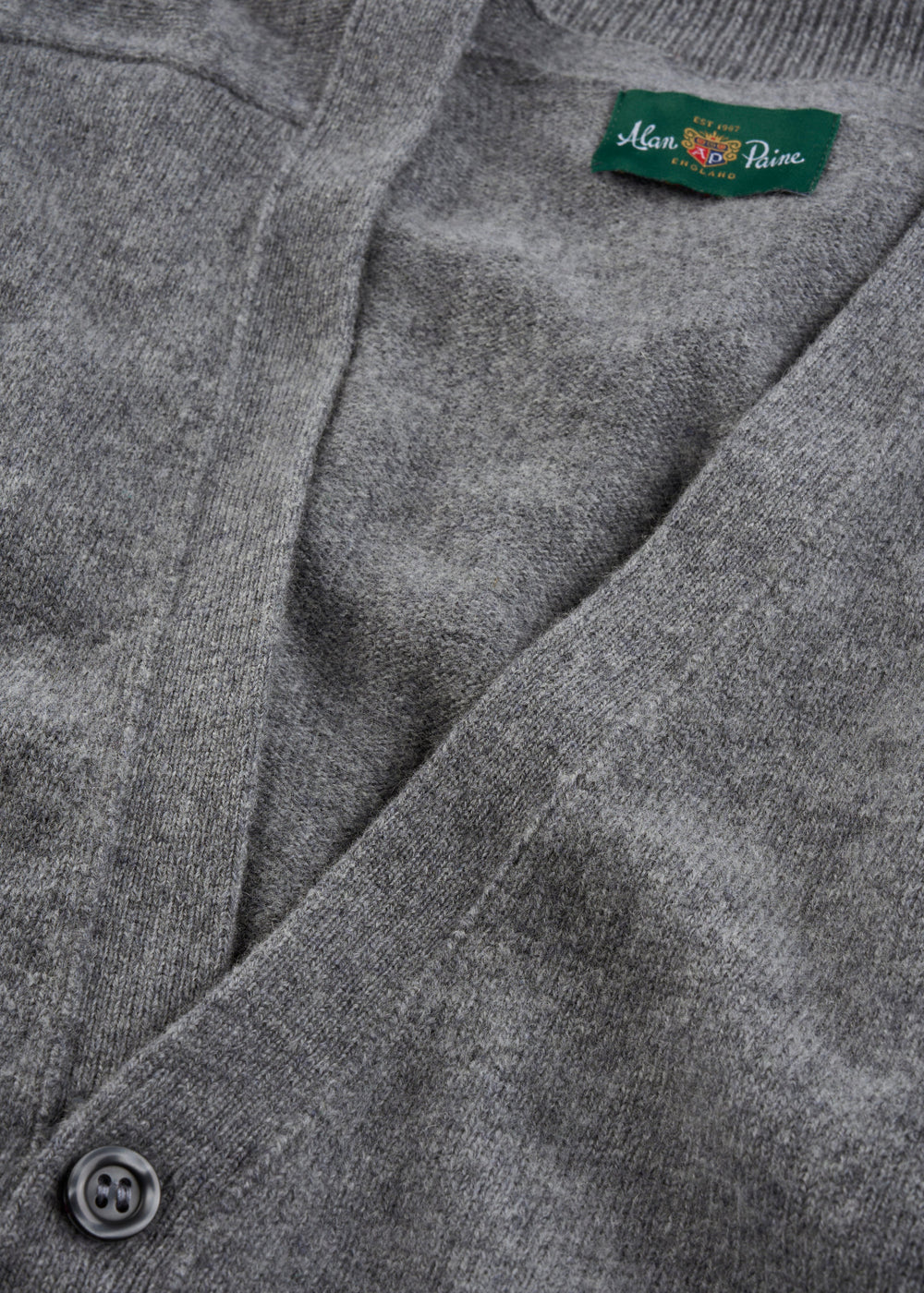 Close-up of Cornwall Lambswool V-Neck Cardigan in Grey Mix—classic fit with button and green Man Prive label.