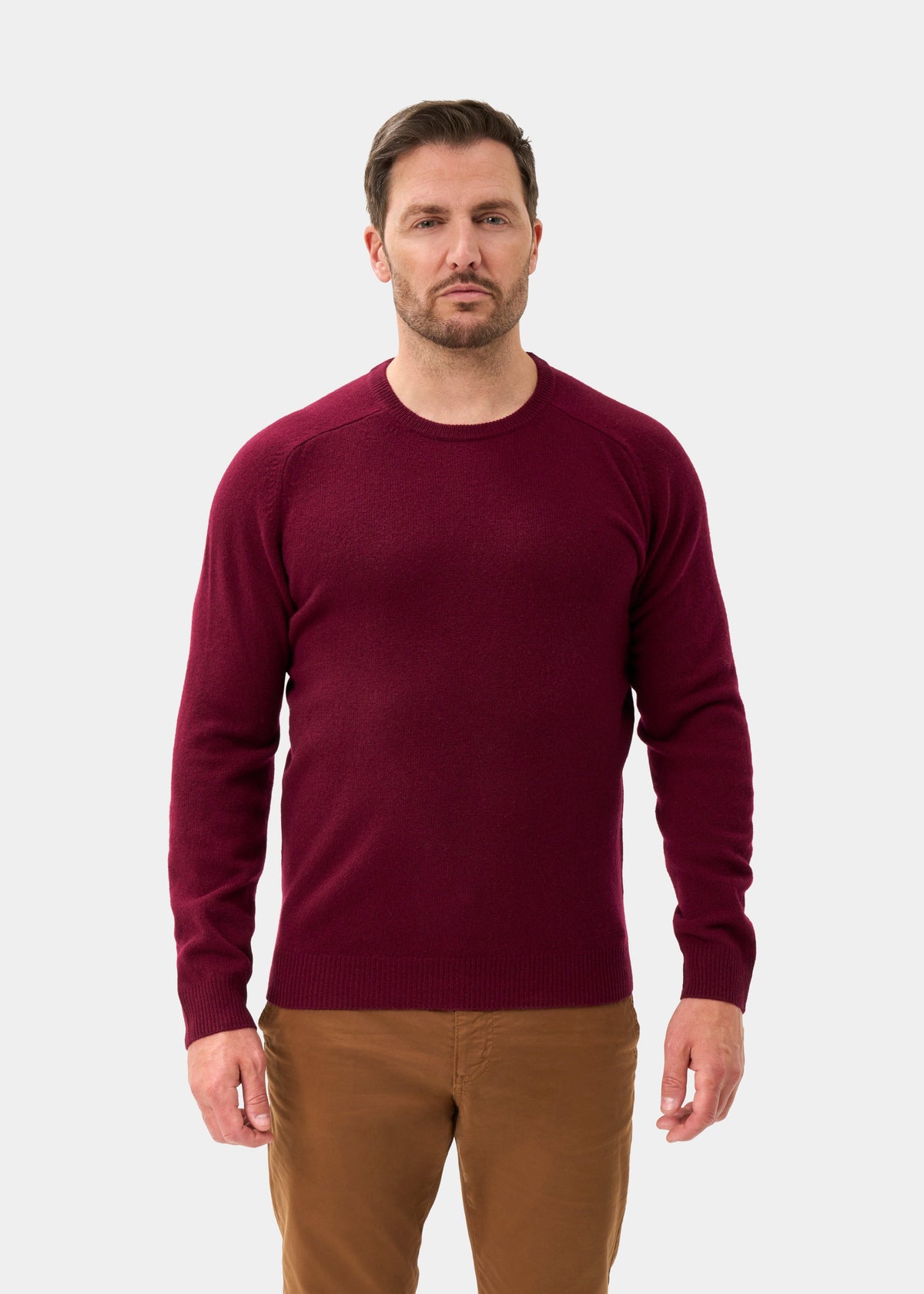 Man wears the Lenzie Lambswool Crew Neck Jumper in Bordeaux, standing forward against a plain light gray background.