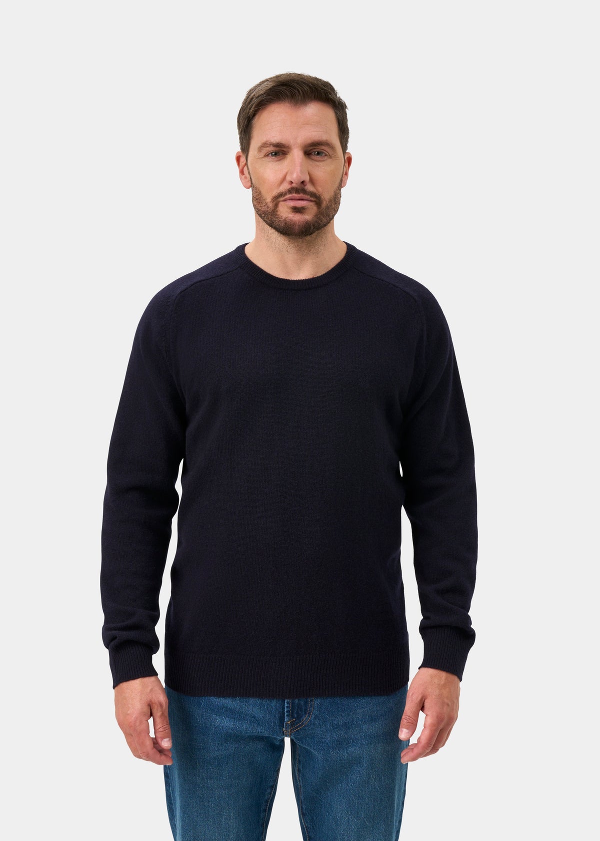 Man with brown hair and beard in Dorset Lambswool Crew Neck Jumper in Navy, classic fit, against plain background.