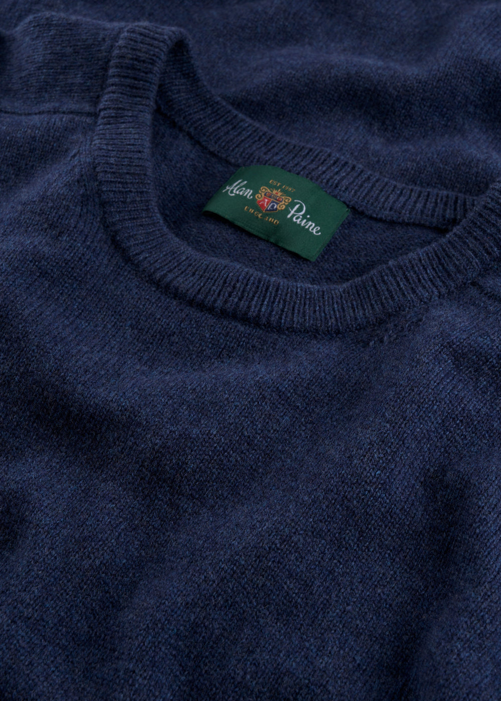 Close-up of the Dorset Lambswool Crew Neck Jumper in Rhapsody, classic fit, with a green John Smedley label.