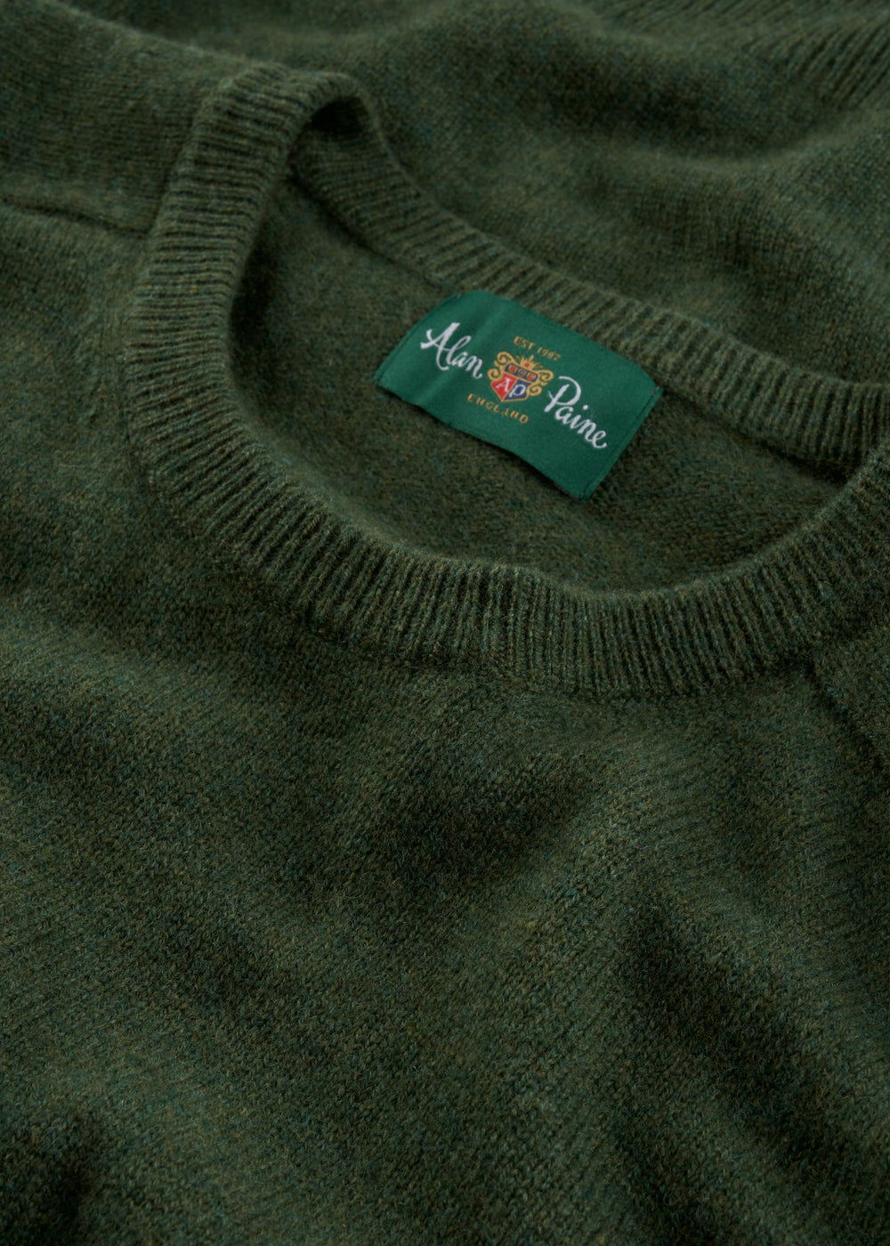 Close-up of Dorset Lambswool Crew Neck Jumper in Rosemary—Classic Fit, Alan Paine England label inside collar.