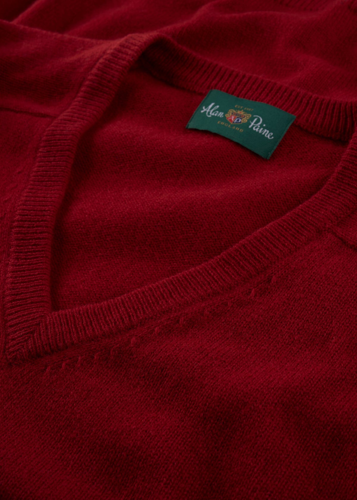 Close-up of the Kilsyth Lambswool V-Neck Jumper in Dubonnet, regular fit, with label inside the collar.