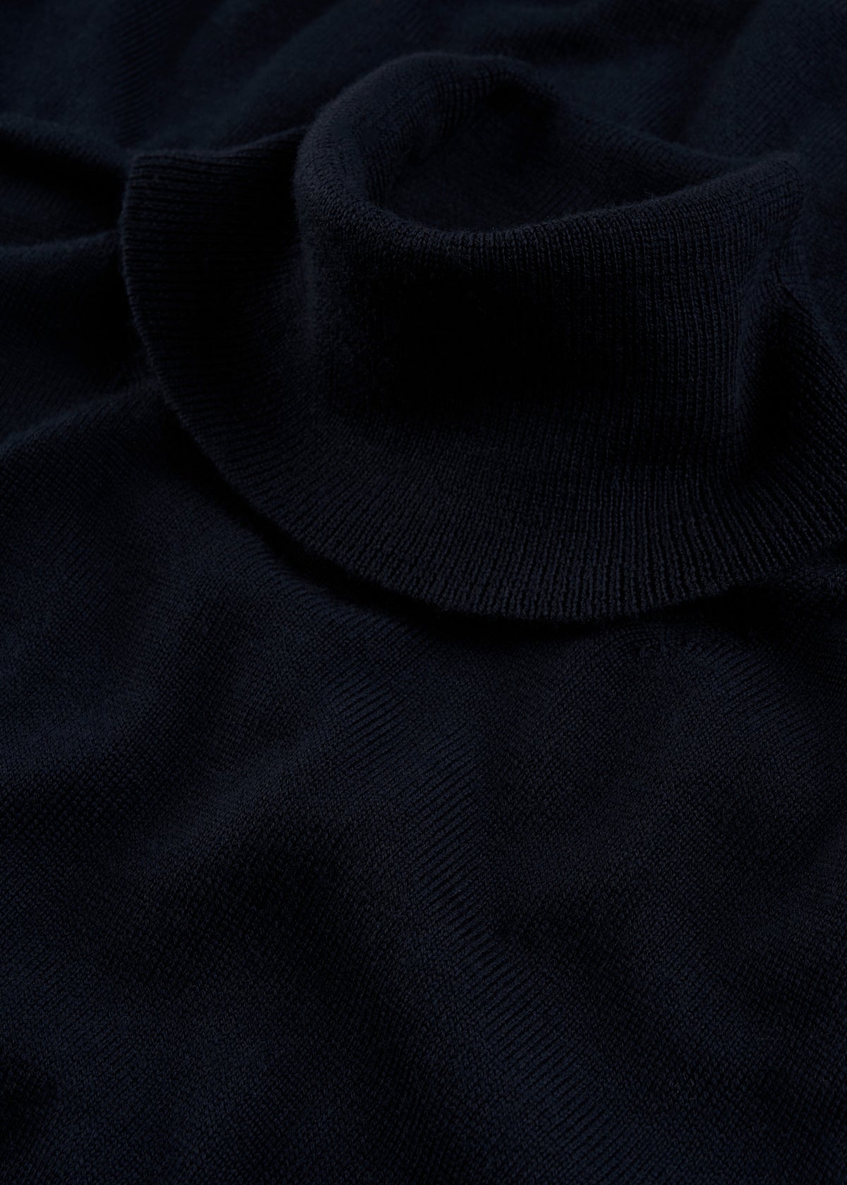 Close-up of Linton Merino Wool Roll Neck Jumper in Dark Navy, showcasing its ribbed collar and soft knit texture.