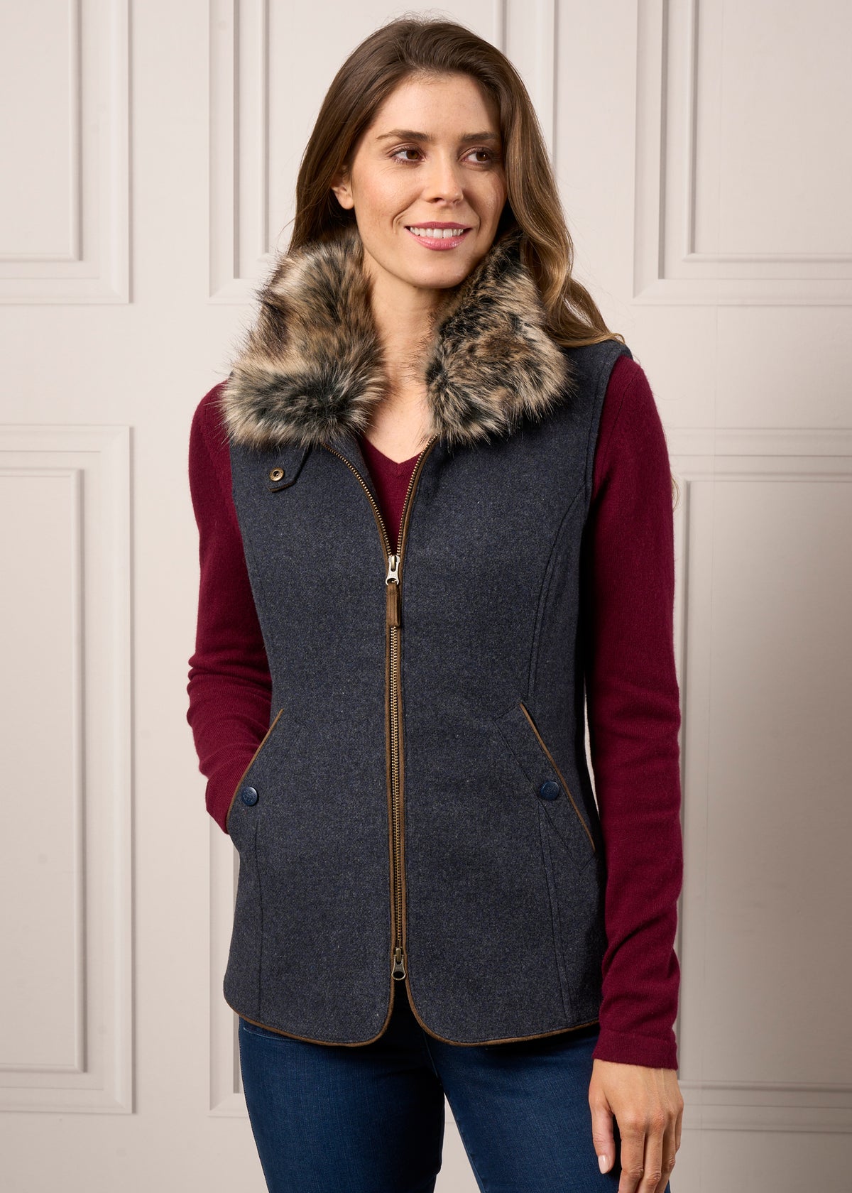 Woman wearing a Surrey Ladies Tweed Water Repellent Gilet in Blue with a faux fur collar over a burgundy sweater.