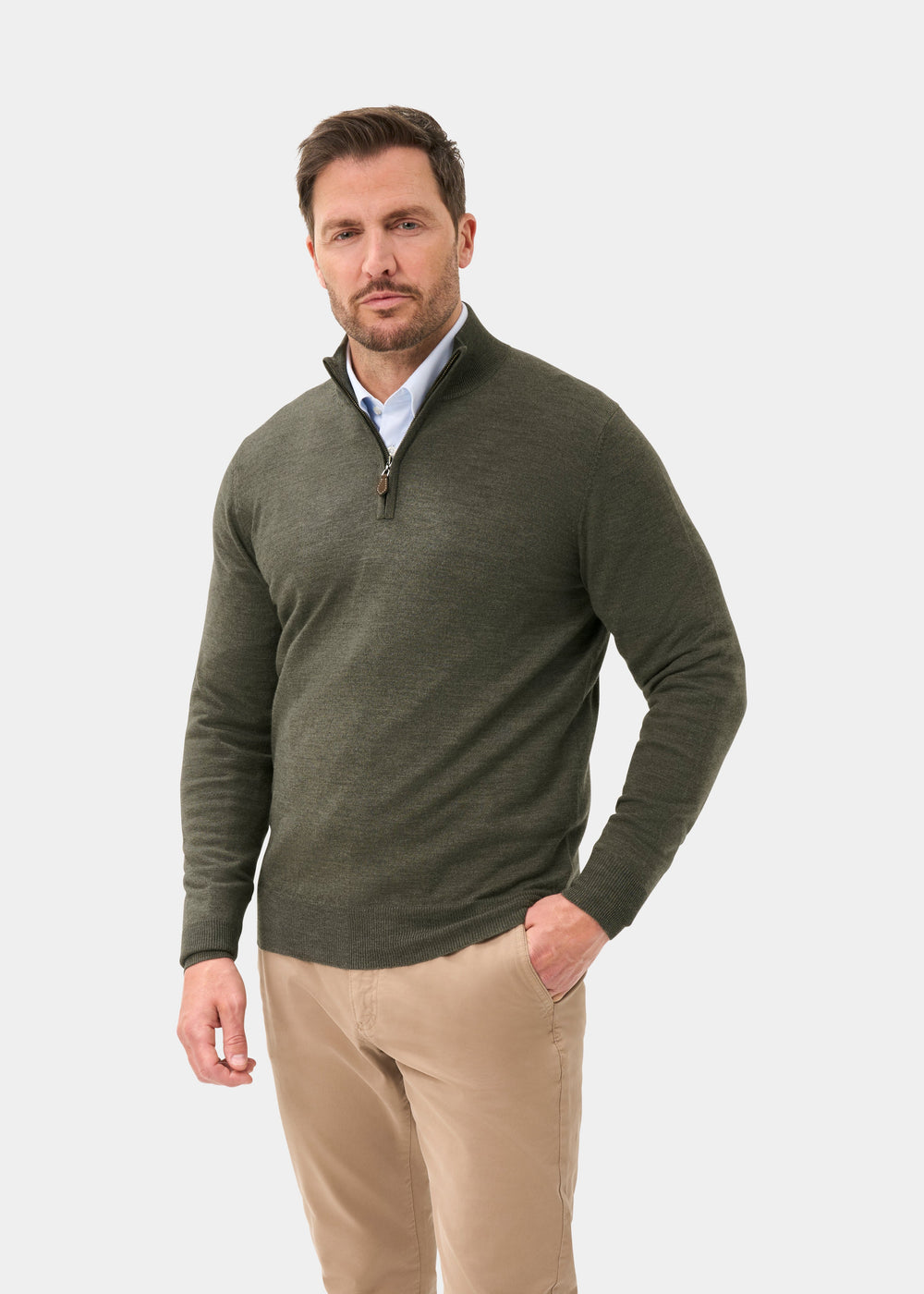 Man wears the Barton Merino Wool Quarter Zip Jumper in Seaweed with khaki pants against a plain white background.